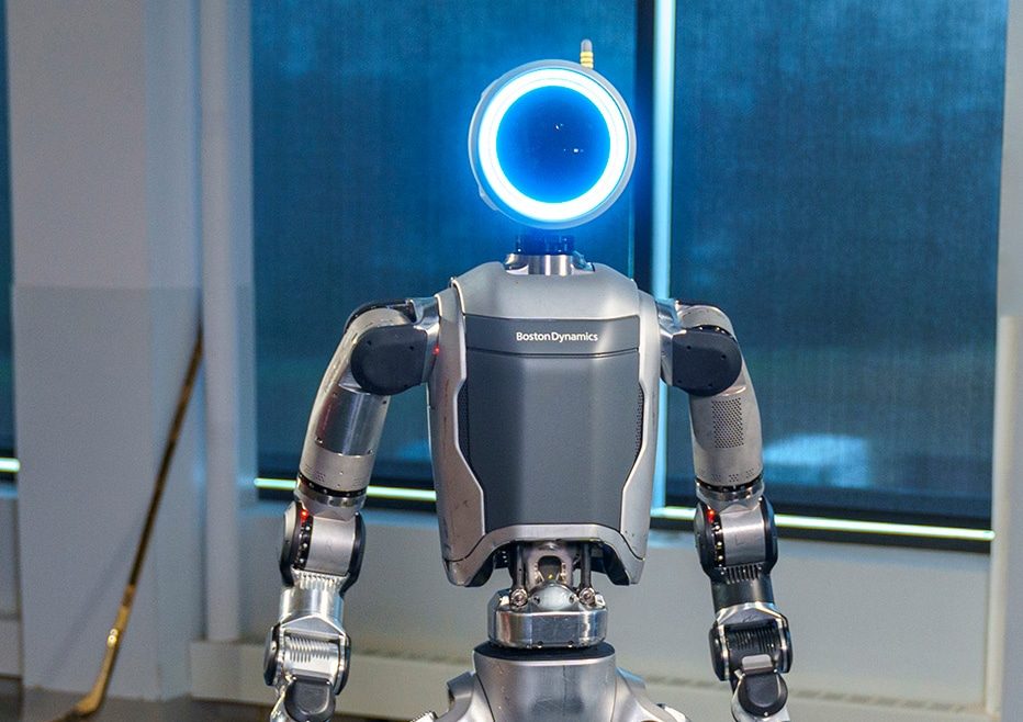 Boston Dynamics' electric Atlas humanoid robot standing against a blue background