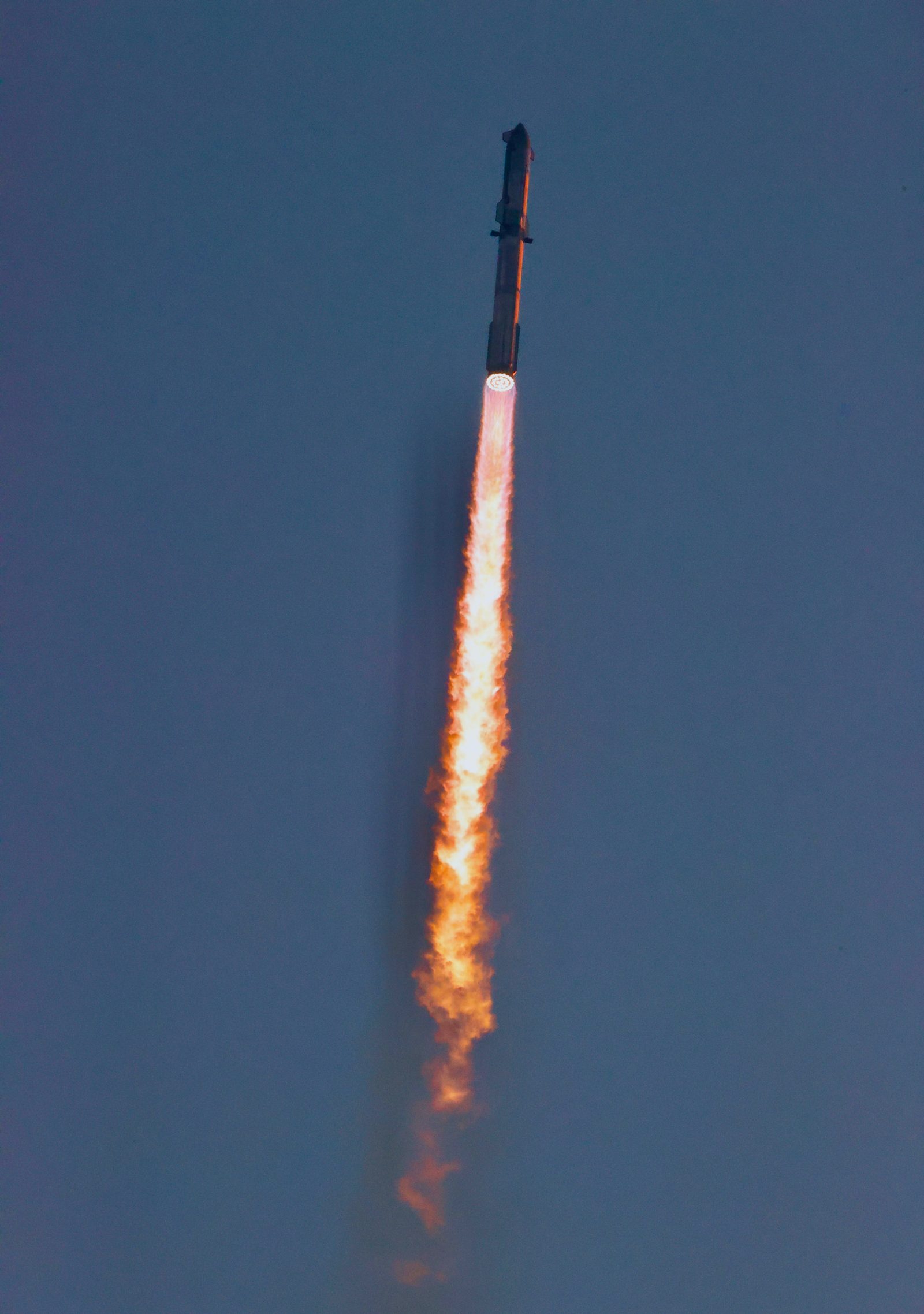 A SpaceX Starship ascends on a column of exhaust during an earlier integrated flight test.
