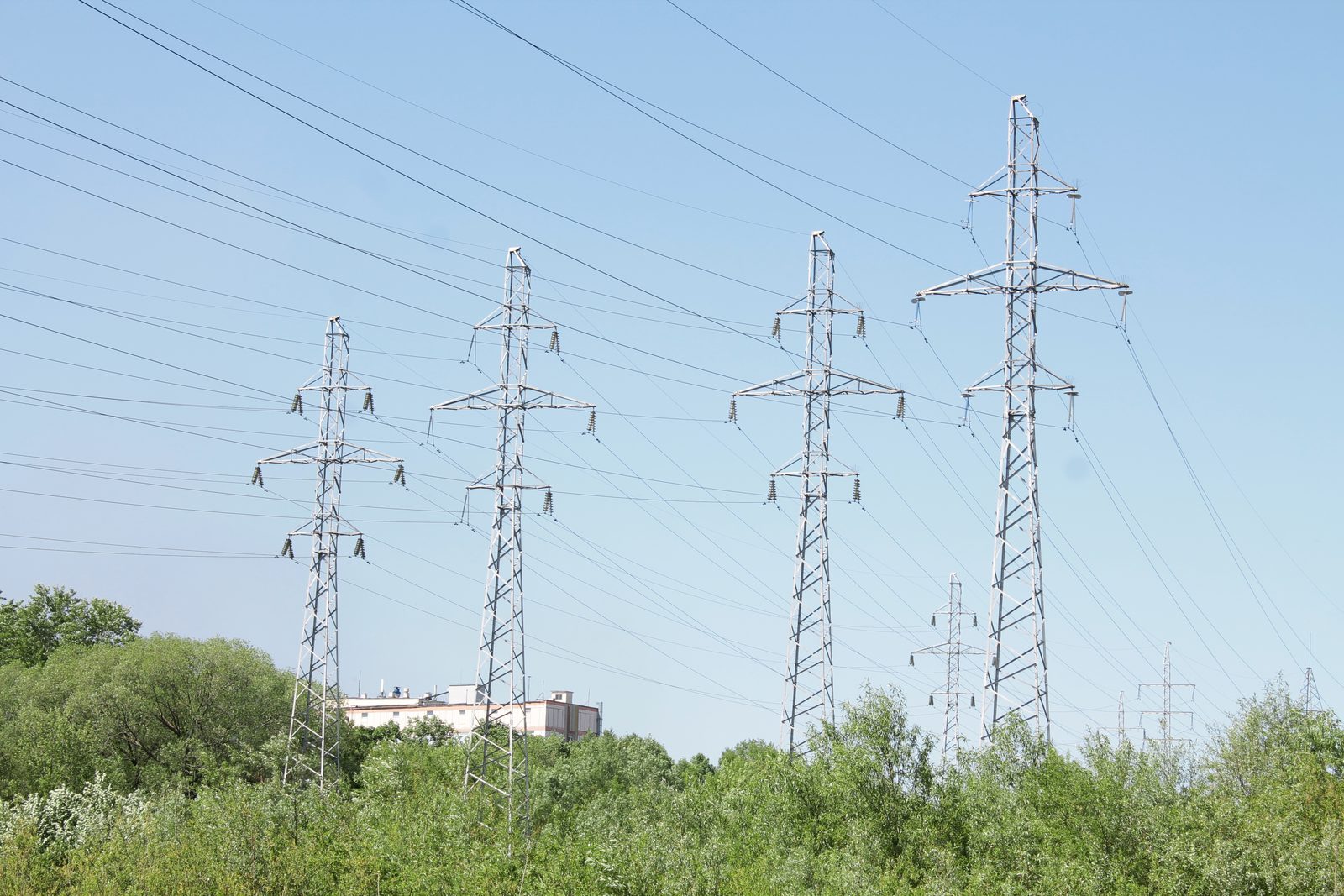 High-voltage electricity transmission tower and power lines against the sky